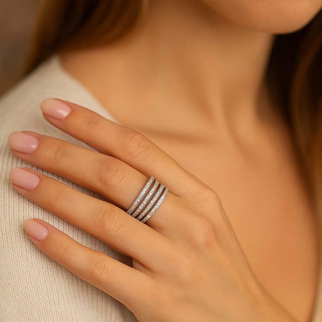 Close-up of a hand wearing multiple rings on a neutral background