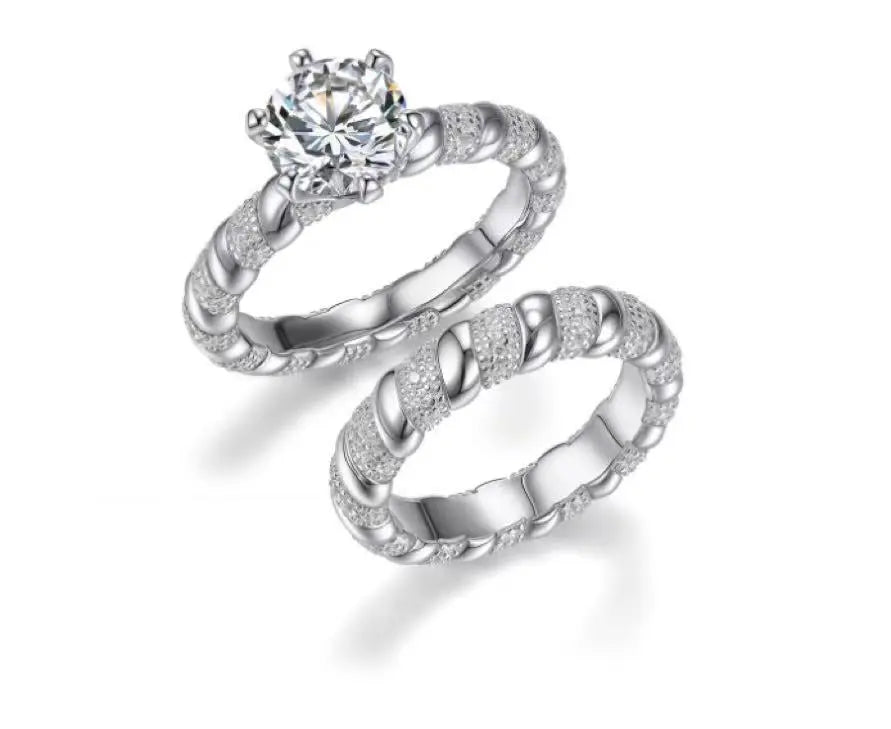 Pair of silver rings with intricate designs on a white background