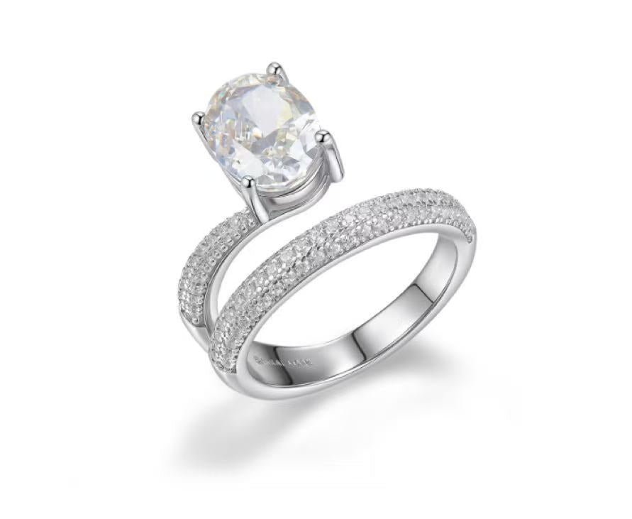 Silver ring with a large central gemstone and smaller stones on a white background
