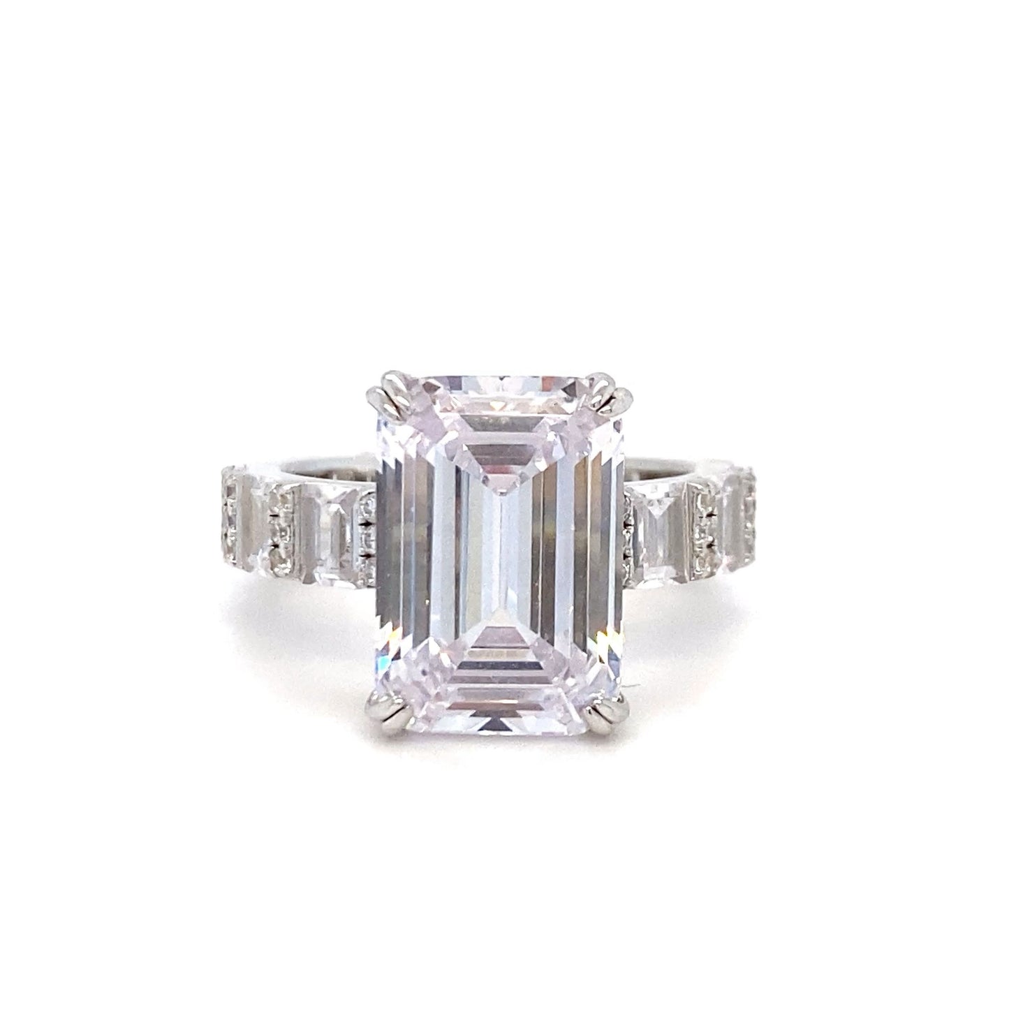 Diamond ring with emerald-cut center stone on a white background