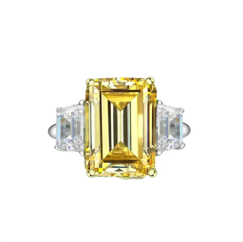 Ring with a yellow gemstone and clear stones on a white background