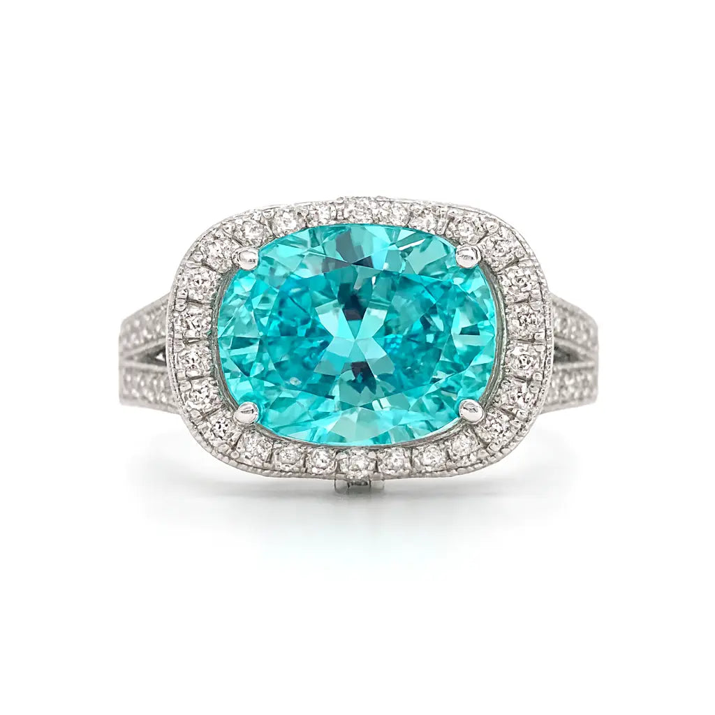 Ring with a large turquoise gemstone and diamond-studded band on a white background