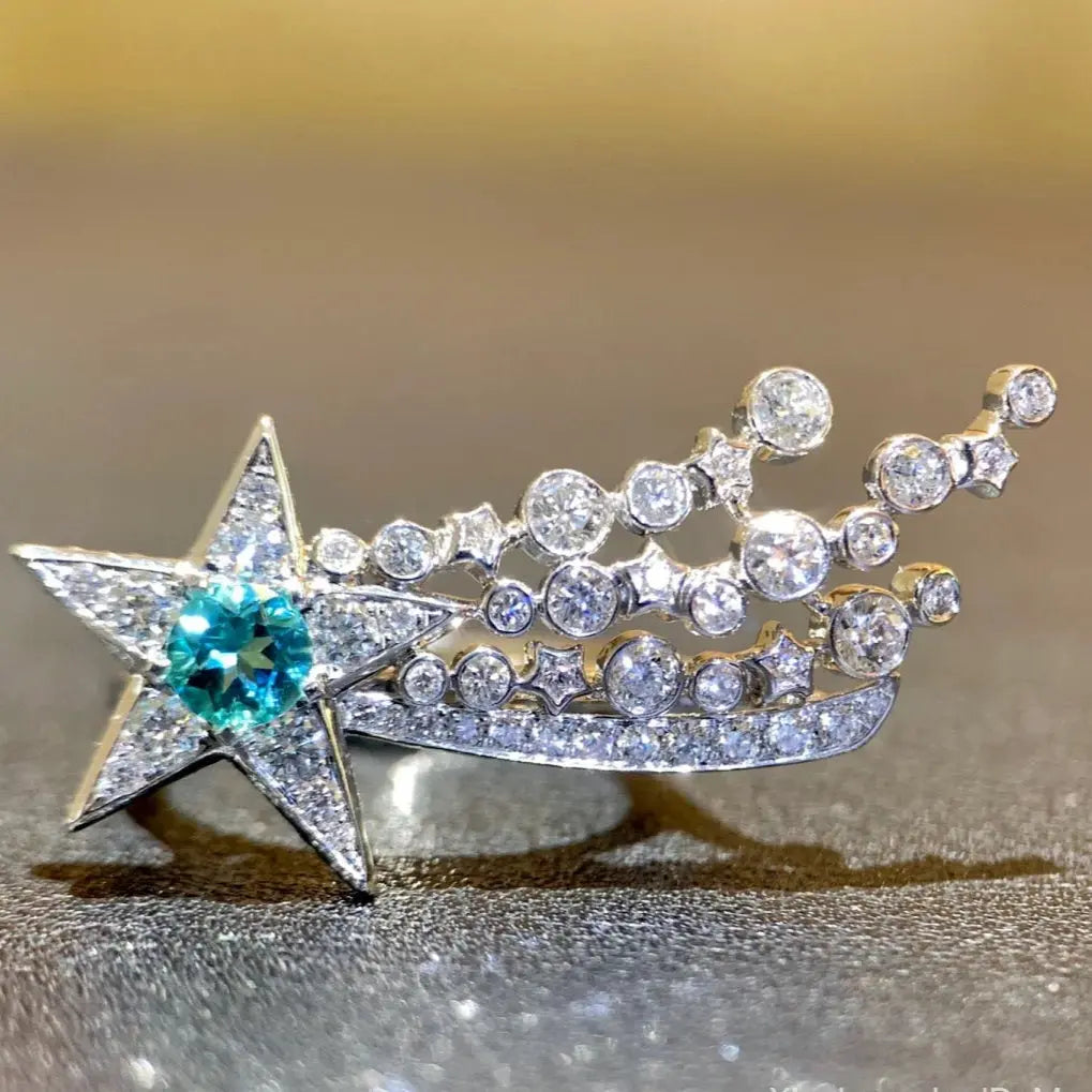 Jewelry item with star design and gemstones on a reflective surface