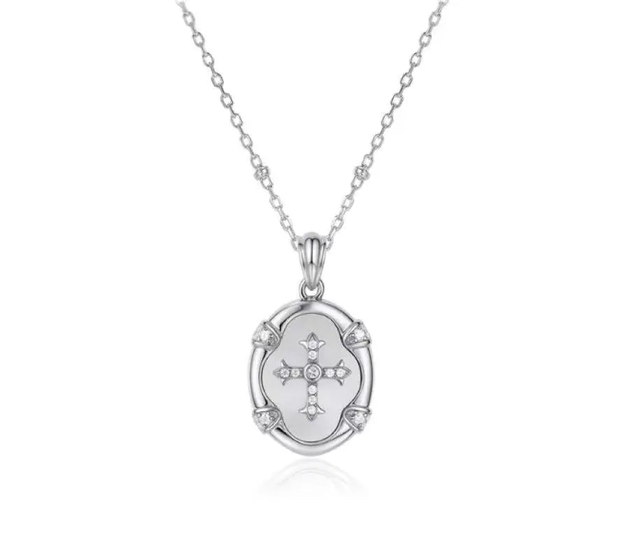 Silver necklace with a pendant featuring a cross design on a white background