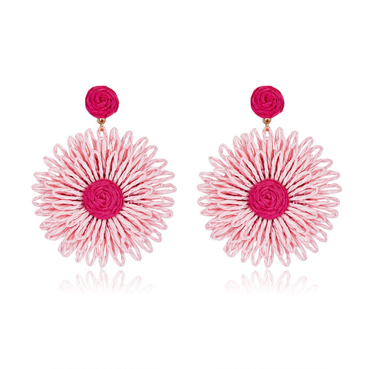 Large woven daisy-shaped earrings called Pink Bloom Drops, featuring light pink petals and a bright magenta center.