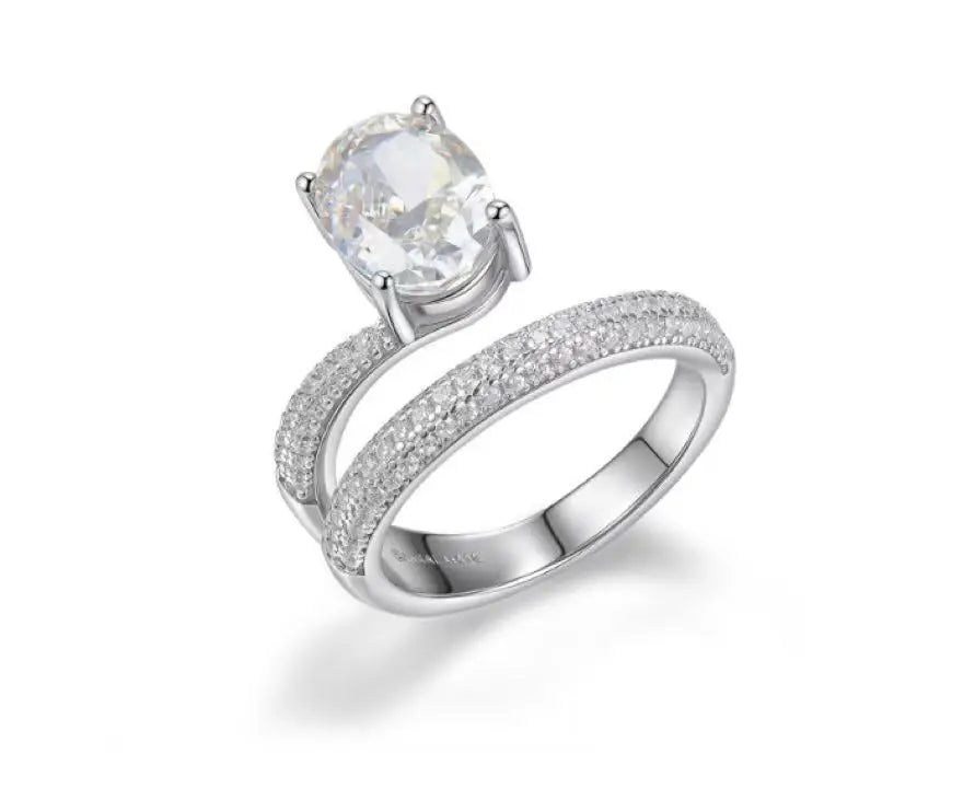 Silver ring with a large central gemstone and smaller stones on a white background