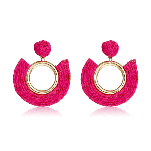 Fuchsia pink half-moon woven earrings with central gold ring.