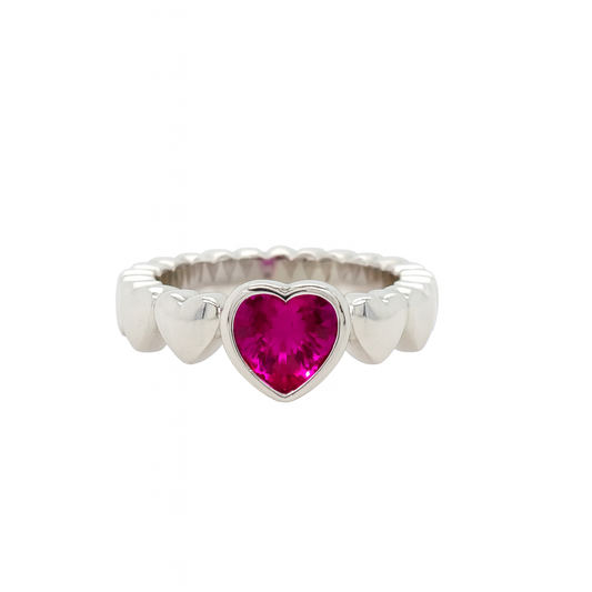 Silver ring with a heart-shaped pink gemstone on a white background