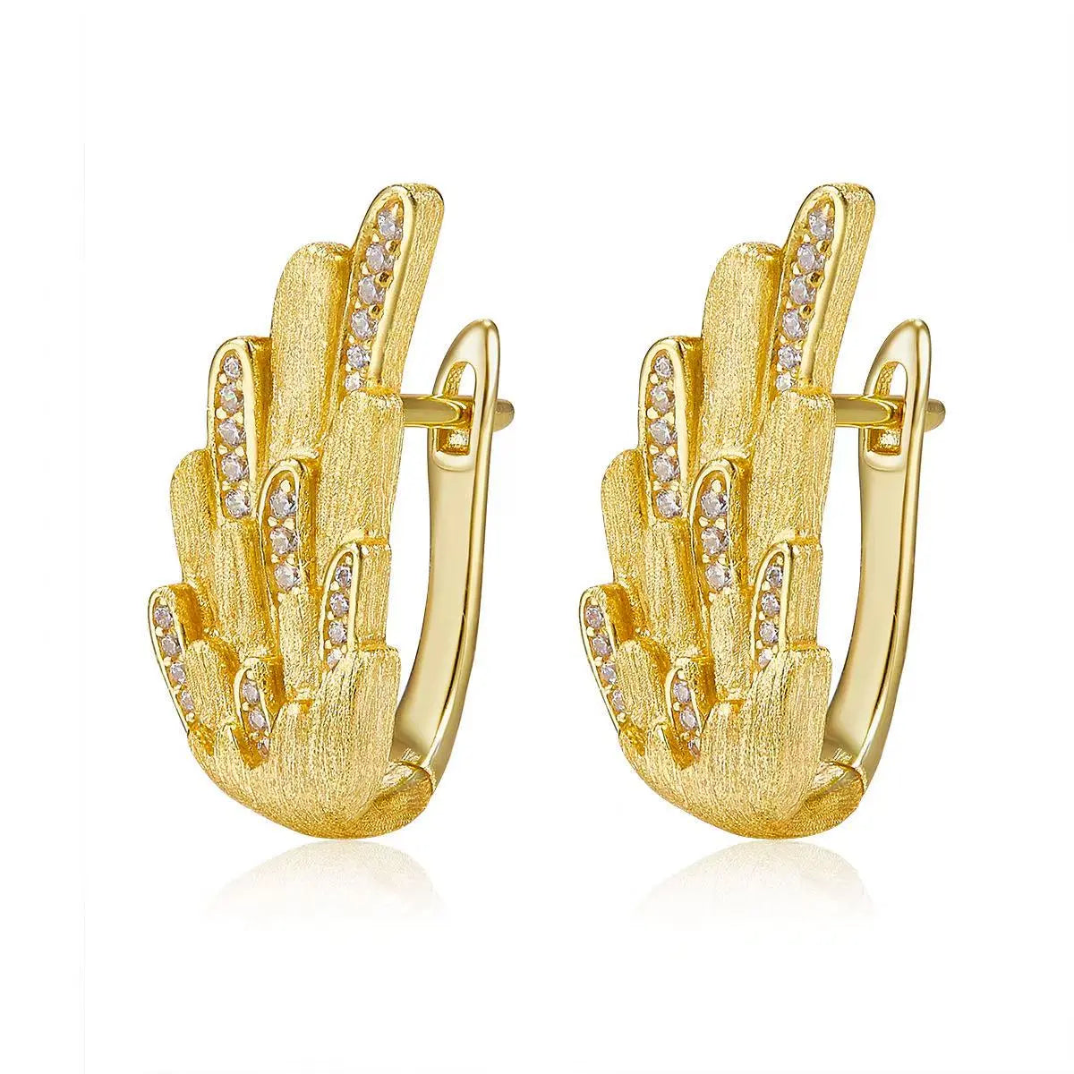 Gold hamsa hand earrings with embedded stones on a white background