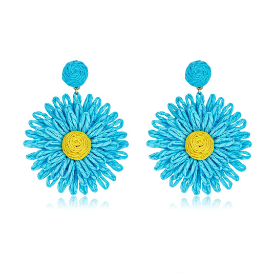 Sky-blue flower earrings with yellow center and round woven stud.