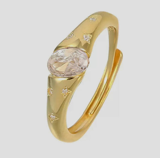 Gold ring with a central diamond on a light gray background