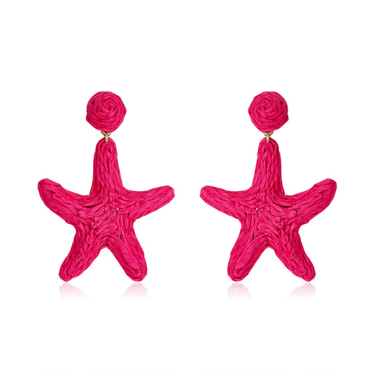 Bright hot pink starfish-shaped earrings made from woven fibers, called Coral Star Drops.