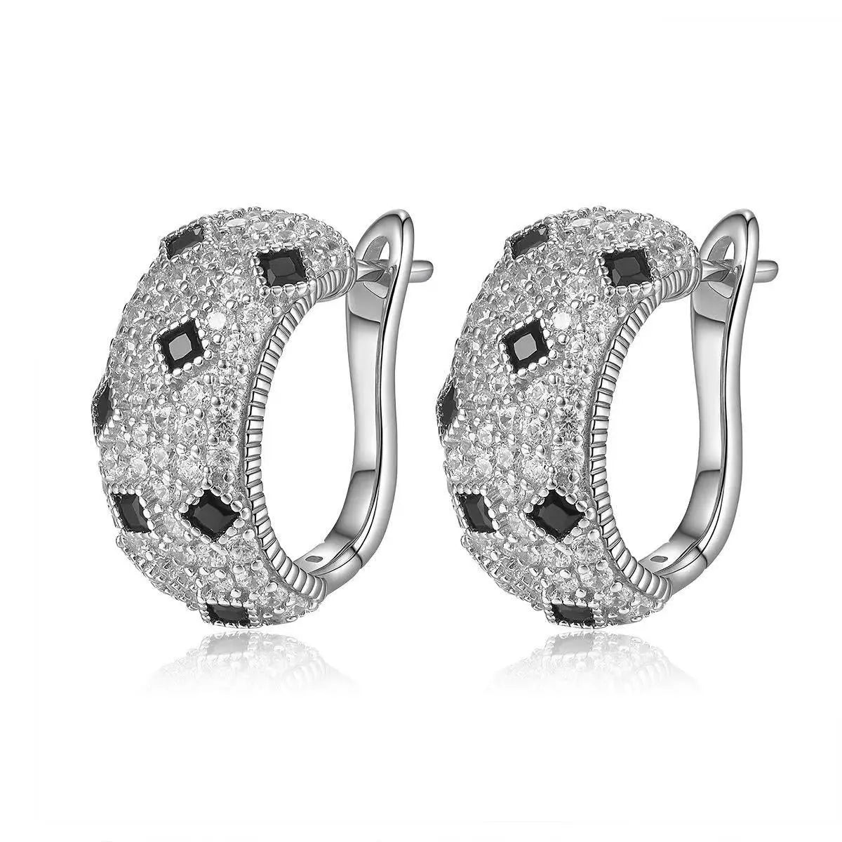 Silver hoop earrings with black and clear gemstones on a white background