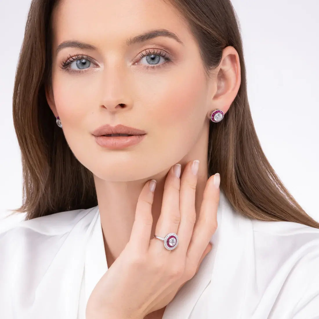 Woman wearing jewelry including earrings and a ring on a white background