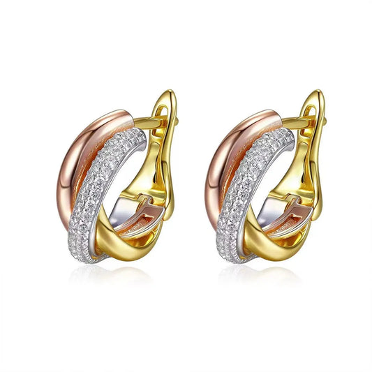 Pair of gold and rose gold hoop earrings with diamond accents on a white background