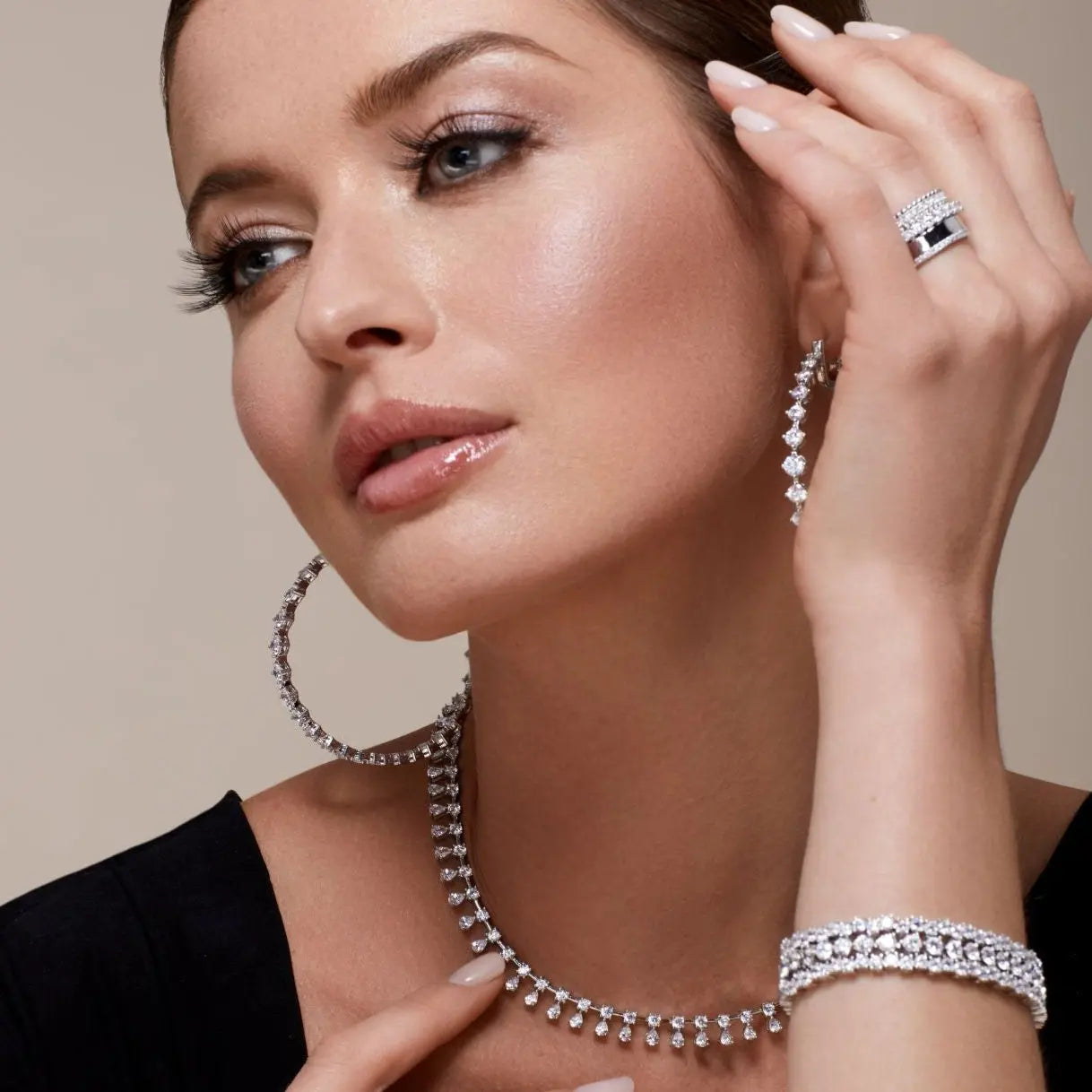 Close-up of model showcasing Anna Zuckerman Mini Pebble Band in Platinum paired with statement diamond earrings, necklace, and bracelet.