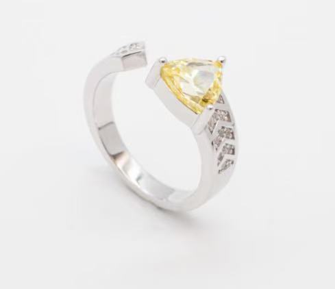 Silver ring with a yellow gemstone on a white background