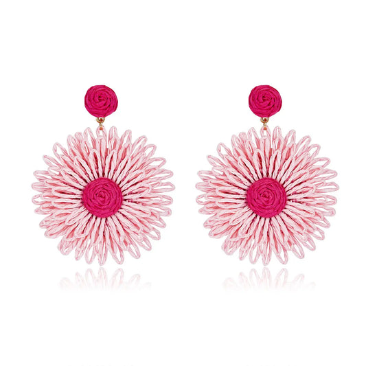 Large woven daisy-shaped earrings called Pink Bloom Drops, featuring light pink petals and a bright magenta center.