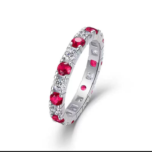 Silver ring with red gemstones on a white background