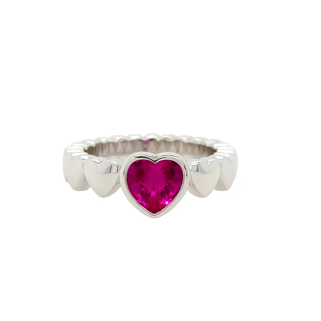 Silver ring with a heart-shaped pink gemstone on a white background