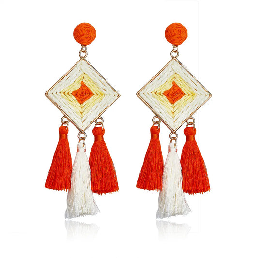 Diamond-shaped woven earrings in orange and ivory with tassel drops, named Sunset Tango Drops.