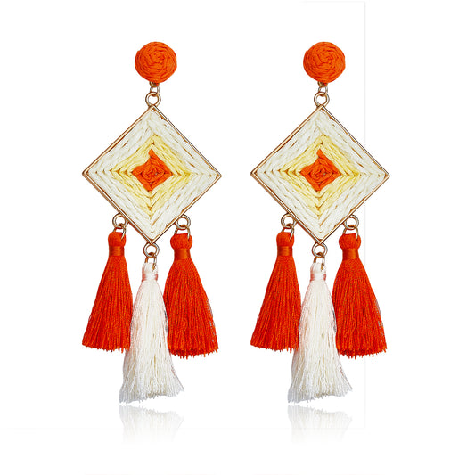 Diamond-shaped woven earrings in orange and ivory with tassel drops, named Sunset Tango Drops.