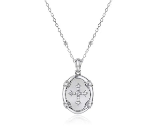 Silver necklace with a pendant featuring a cross design on a white background