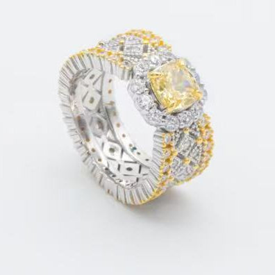 Luxury ring with yellow gemstone and diamond accents on a light gray background