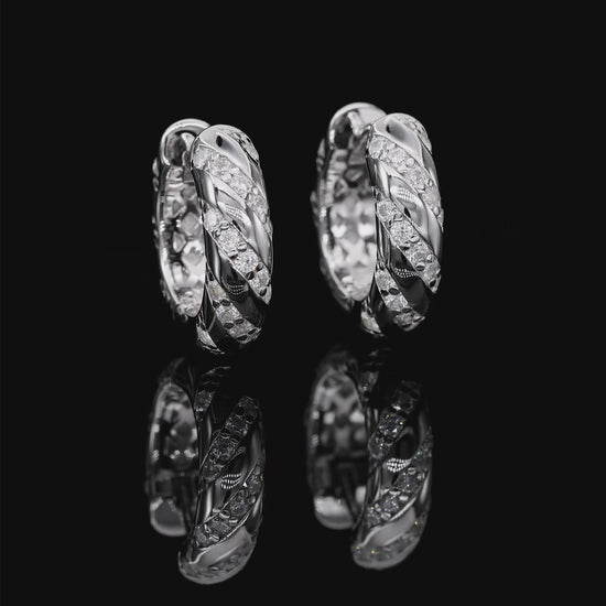 Pair of silver hoop earrings with diamond accents on a white background