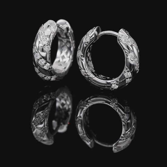 Pair of silver hoop earrings with diamond accents on a white background